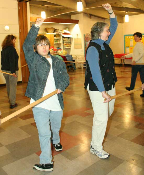 Abby Browse (left) and Cary Browse hold wooden swords as they practice a traditional English dance for the annual solstice service at the Unitarian Universalist Church.
