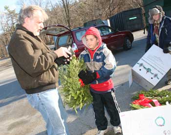 Brian Schimpf of Littleton Road buys a wreath at the transfer station from Cub Scout Pat Pesa as Rory Wirch (far left) looks on. (Photo by Lisa Aciukewicz) Brian Schimpf of Littleton Road buys a wreath at the transfer station from Cub Scout Pat Pesa as Rory Wirch (far left) looks on. (Photo by Lisa Aciukewicz)