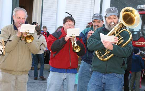 The Harvard Town Band plays carols in front of the Congregational Church. The horn section includes (left to right) John Davis, Jim Wallace, Steve KeVille, and Charlie Leach.