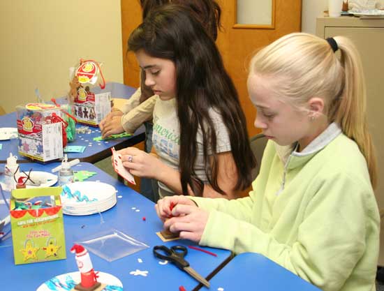 Seventh graders, Mackenzie Grant (left) and Karen Shaw make Christmas ornaments at a youth group fundraiser at St. Theresa’s.
