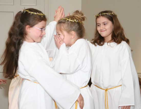 Katie Erdos, Bailey Bourgeois, and Brigitte Lewis practice an angel dance for the ecumenical Christmas pageant.