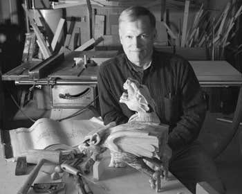 Pete Jackson poses with the gargoyles he helped recreate for the new public library. The original gargoyles were badly damaged. Pete carved new pieces to repair the creatures and created resin duplicates to return to their roost atop Bromfield. (Photo by Richard Wolfson) Pete Jackson poses with the gargoyles he helped recreate for the new public library. The original gargoyles were badly damaged. Pete carved new pieces to repair the creatures and created resin duplicates to return to their roost atop Bromfield. (Photo by Richard Wolfson)