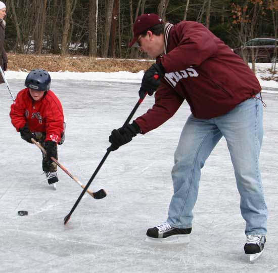 Ben Harris takes a puck passed by Jeff Manning on the ice at the town resevoir.