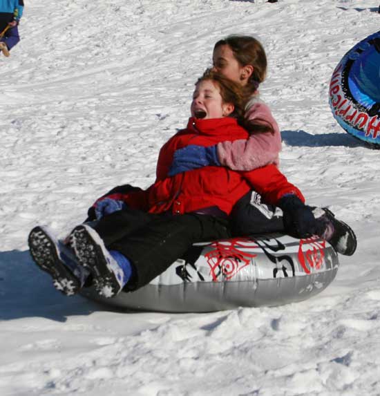Haley Newsham and Alena Davis hold on for dear life as they head down hill on a snow tube.