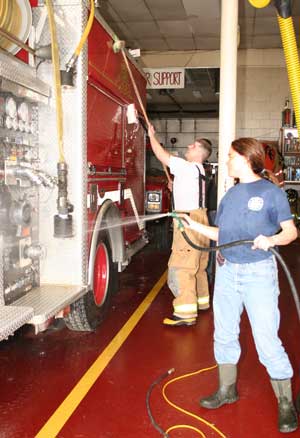 Firefighters Oona Aldrich and Sean Murphy wash down the pump truck, Engine 4. (Photo by Lisa Aciukewicz) 