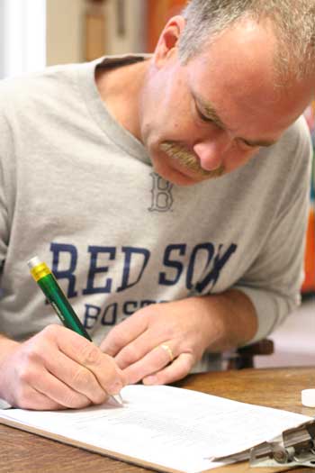 Lieutenant Rob Warren, a 17-year member of the fire department, fills out an incident report after a call. (Photo by Lisa Aciukewicz)