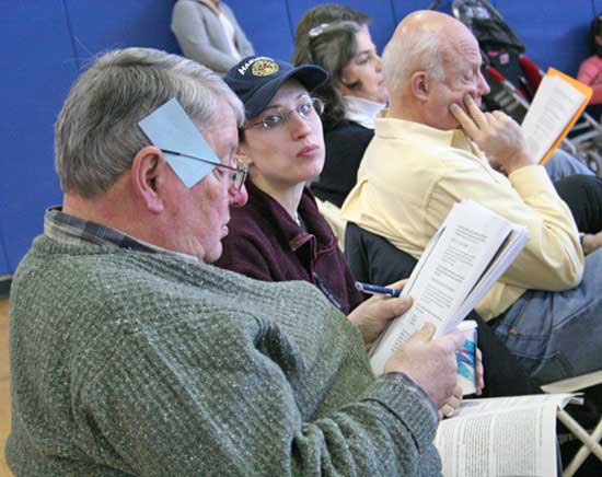 Former Fire Chief Peter Warren studies the warrant.