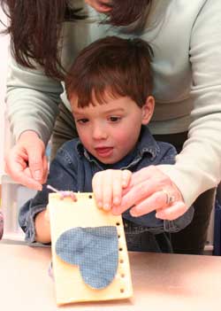 Ben Hayes gets help sewing his quilt square. (Photo by Lisa Aciukewicz) Ben Hayes gets help sewing his quilt square. (Photo by Lisa Aciukewicz)