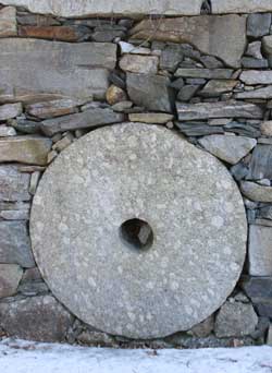 A millstone built into the wall near the herb shed. (Photo by Lisa Aciukewicz) A millstone built into the wall near the herb shed. (Photo by Lisa Aciukewicz)