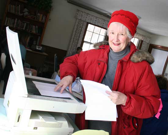 Veteran Good Friday walker and volunteer Charlanne Van Wormer copies a pledge sheet.