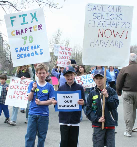 Eli Wood, Ross Brown-Cullinane, and Mitch Sklar show their handcrafted signs on the Boston Common.