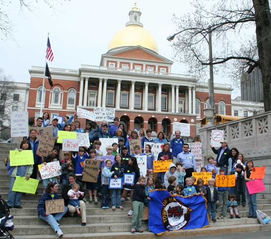 A group of Harvard citizens poses on the steps in front of the State House.