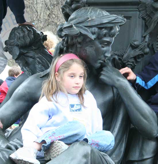 Nina Sklar takes a break, relaxing on a statue in a not-yet-filled fountain.