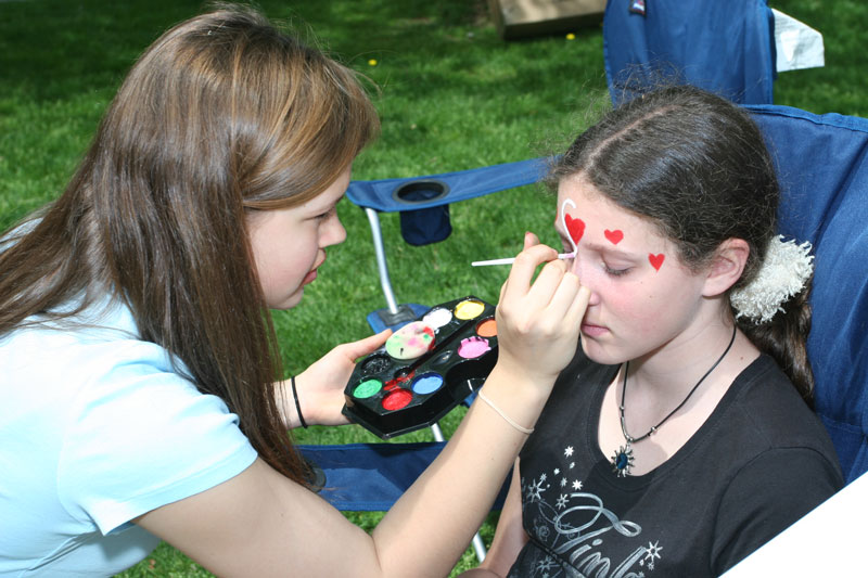 Erica Schwiegershausen paints Colleen O'Shea's face.