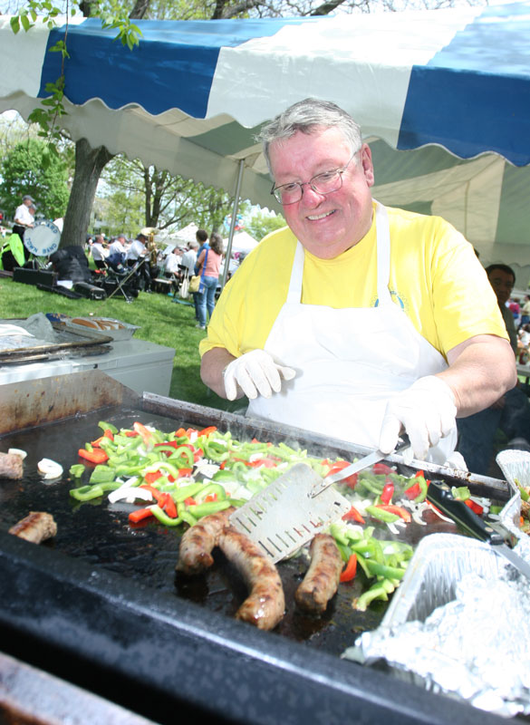 Peter Warren adeptly mans the grill at last weekend's Apple Blossom Festival, cooking up sausages with peppers and onions.
