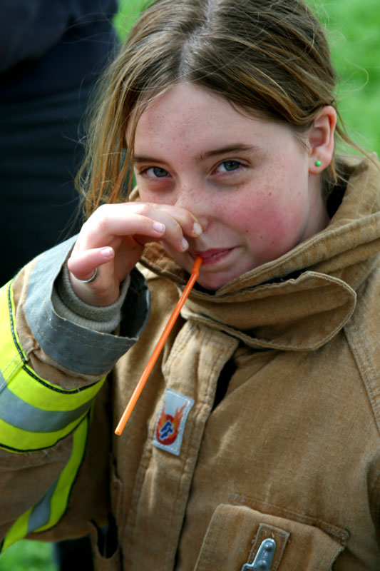Camilla Vilain breahes through a straw with one nostril pinched to get a feeling for what long-term smokers expeience as a result of obstructed air passageways. The demonstration was put on by the Harvard firefighters.
