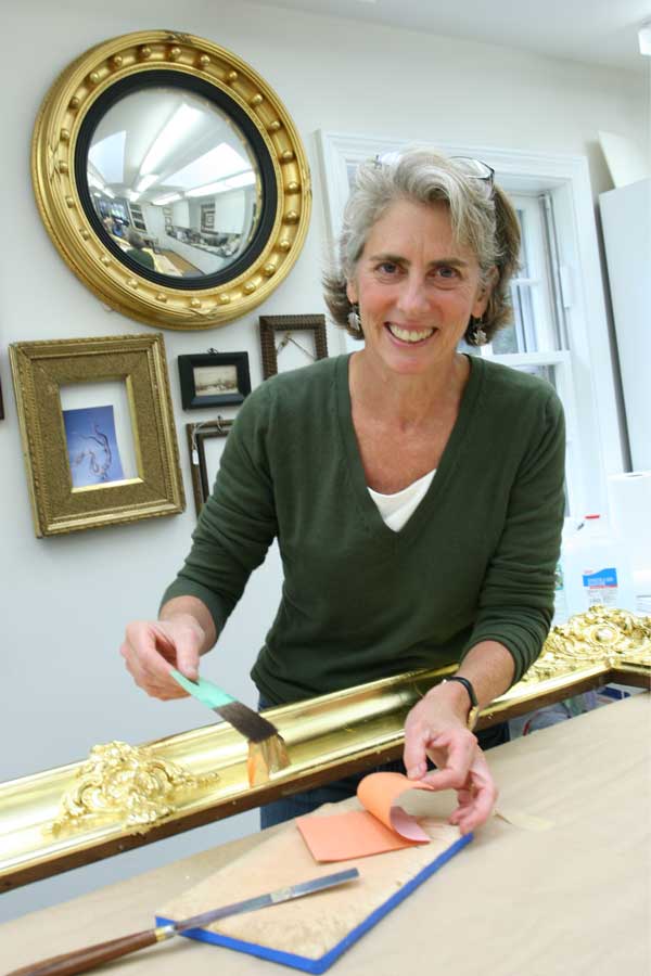 Sue Jackson applies gold leaf to a frame in her studio. (Photo by Lisa Aciukewicz) Sue Jackson applies gold leaf to a frame in her studio. (Photo by Lisa Aciukewicz)