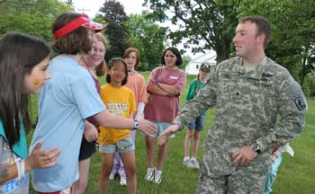 Left to right: Leanne McDonald, Kelly O’Shea, Allison Rizzo, Kiera Jean Frost, Lauren Beale, Annie Cooper, Jenny Specht, and Specialist Jon Farwell meet on the Common for ice cream and conversation.