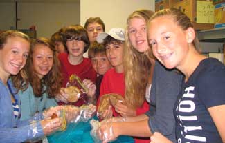 Youth group members Kiley Nygren, Sarah Duckett, Billy McNamara, Owen Alderson, Justin Ruenheck, Lucas Hickok, Rhett Nuenighoff and Sophie Aney bag cookies donated by Harvard Sweet Boutique to Loaves and Fishes food pantry in Devens. (Courtesy photo) Youth group members Kiley Nygren, Sarah Duckett, Billy McNamara, Owen Alderson, Justin Ruenheck, Lucas Hickok, Rhett Nuenighoff and Sophie Aney bag cookies donated by Harvard Sweet Boutique to Loaves and Fishes food pantry in Devens. (Courtesy photo)