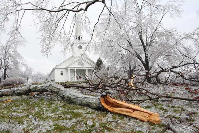 Ice and tree limbs cover the Common in front of the Unitarian Universalist Church.
