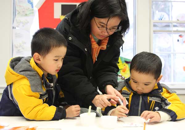 Andrew, Rosalind, and Charles Chen make crafts at the Harvard Family Association Egg Hunt.