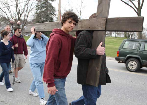 James Gordon shoulders a cross with his parents on the third-annual Procession of the Cross from St. Theresa’s Church in Harvard to St. Francis Xavier Church in Bolton on Good Friday