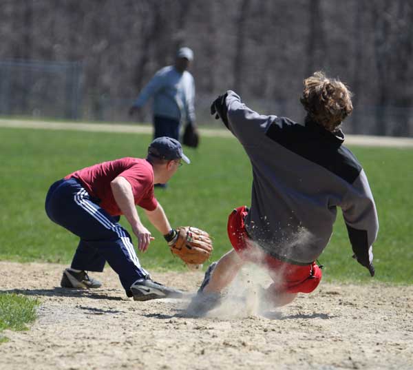 Erik Shoepke waits for the throw as James Stamm slides into second base during opening day of senior softball at the elementary school field. The league started its 33rd season on Sunday.
