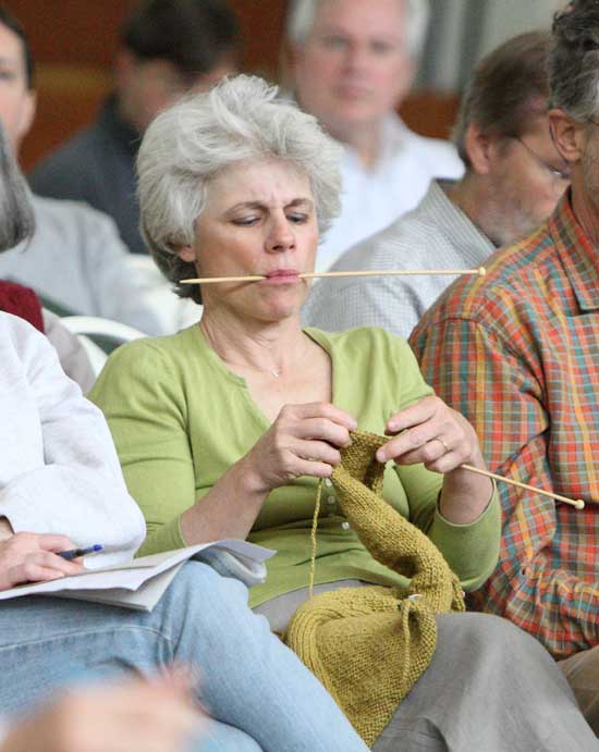 Roseanne Saalfield knits as she listens to the speakers.