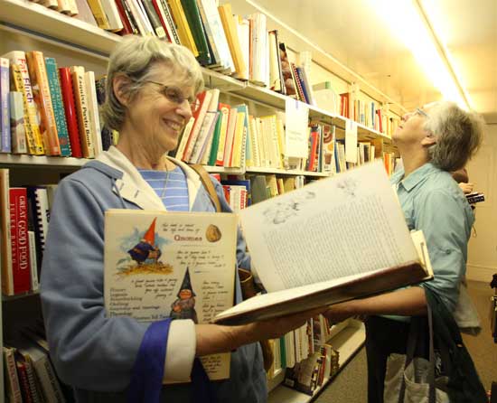 Judy Warner (left) and Faith Cross check out the shelves of books at the Friends of the Harvard Public Library book sale in the old library on Saturday, May 9.