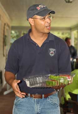 Police Chief Ed Denmark hands out watermelon at a barbecue for town employees last July. (Photo by Lisa Aciukewicz) Police Chief Ed Denmark hands out watermelon at a barbecue for town employees last July. (Photo by Lisa Aciukewicz)
