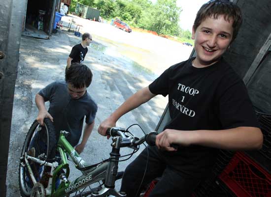 Boy Scout Ed Talanian lifts a bicycle onto a box truck at the transfer station. Ed collected donated bicycles for recycling by Bikes Not Bombs, an organization that promotes bicycle technology as an alternative to war and environmental destruction. 