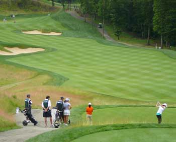 A group tees off on the scenic 14th hole with its unusual punchbowl-shaped green. (Photo by Worth Robbins)