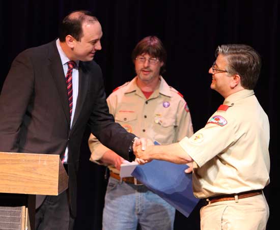 State Senator Jamie Eldridge (left) present Bob Hubert (right) with a commendation for his work with the Boy Scouts as Greg Smith looks on.