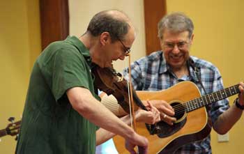 David Kassel and David Atwood play some “old time” music at an Ecumenical Youth Group coffehouse in Volunteers Hall on June 25 to benefit Monicah Kivaa, an Assumption College sophmore from Kenya who has ties to Harvard. Kassel and Atwood played in the Route 111 Valley Boys along with Gary Shaw and Stuart Ervin. (Photo by Lisa Aciukewicz)