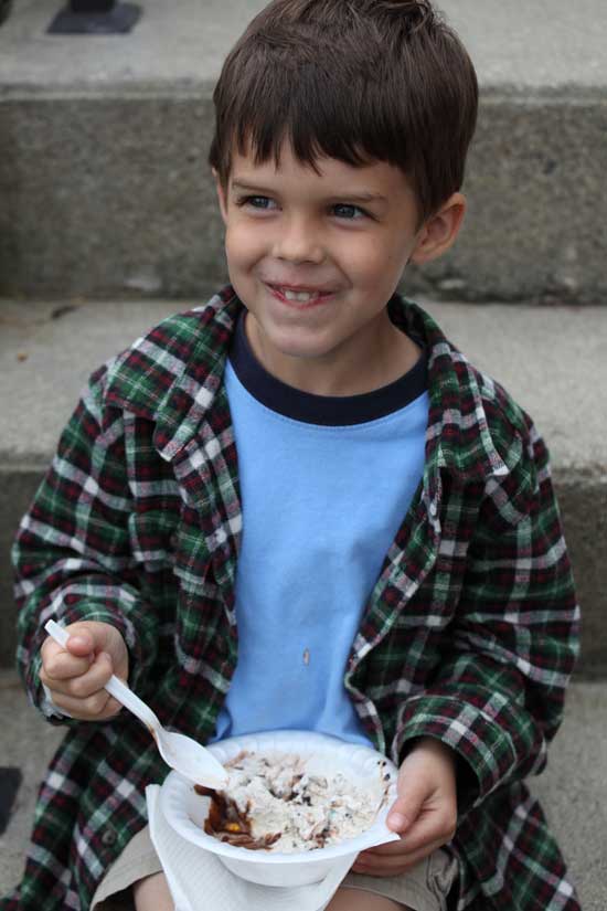 Four-year-old Liam O'Toole from Georgia digs into a bowl of ice cream at the library's summer reading kickoff celebration. Liam's family vacations on Bare Hill Pond every summer.