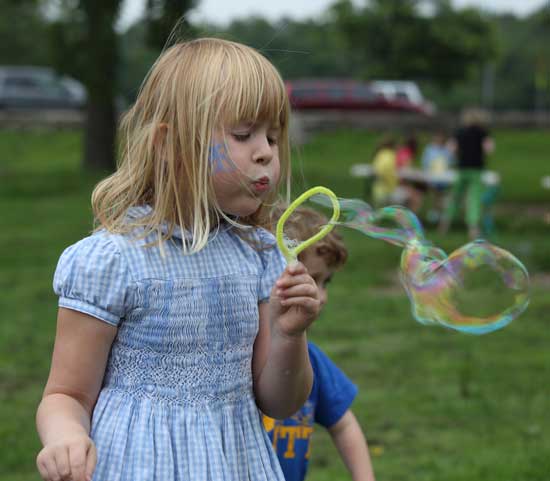Daniella Piper blows bubbles at the library's ice cream social.