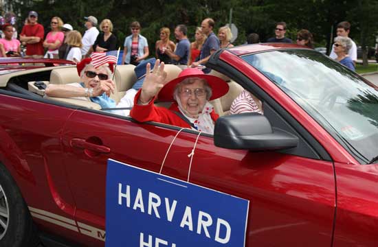 Lois Doe and Phyllis Newman wave to the crowd from the Harvard Help float.