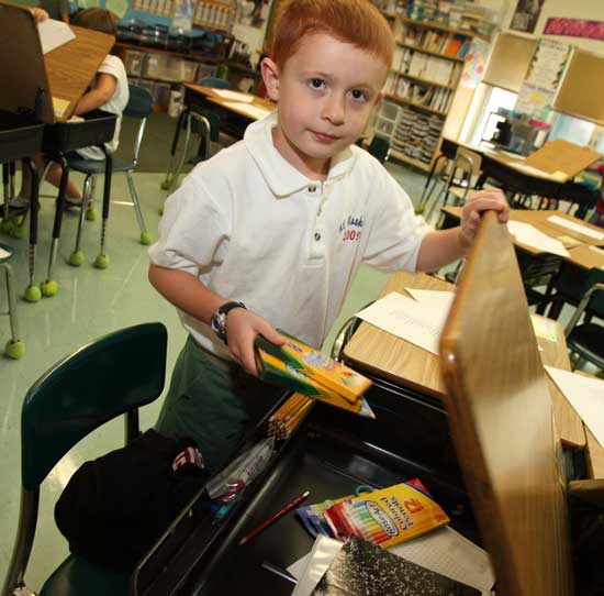New fourth-grader Samuel Thieme of Devens unpacks his school supplies.