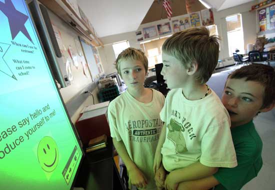 Brothers (from left) Kenny, Jason, and Michael Morin check out a SMARTBoard at the elementary school open house in September. The new school year brought SMARTBoards to 20 classrooms.