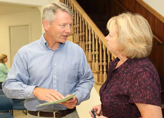 Bill Johnson, one of two candidates for selectman, speaks with Town Clerk Janet Vallente at the town caucus on Sept. 21.