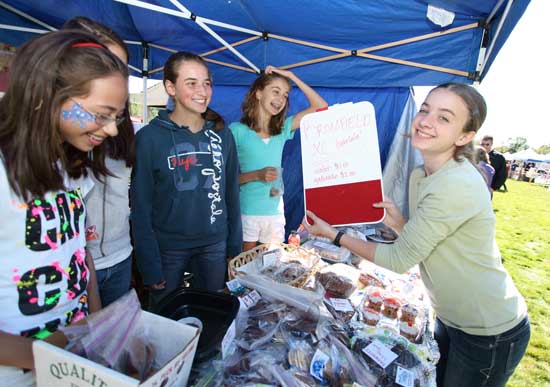 From left, Maddie Beckman-Ogut, Julie Gormley, Hannah McDonald, and Sophia Collins sell baked goods to raise funds for the Bromfield cross country team.
