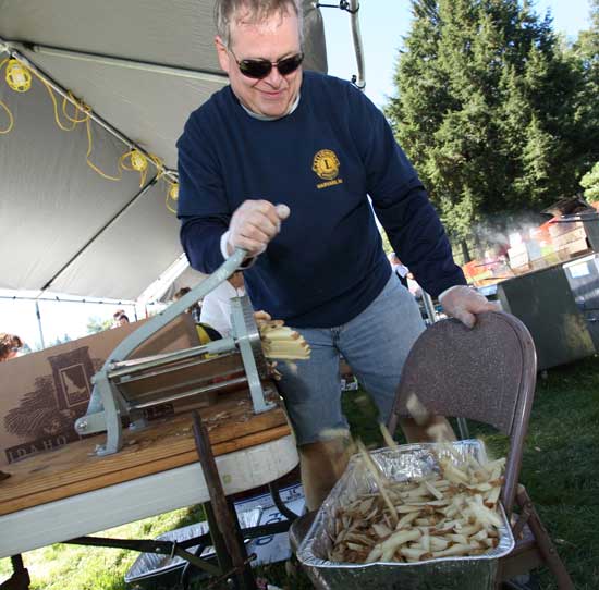 Lions Club member Scott Comstock transforms potatoes into fries