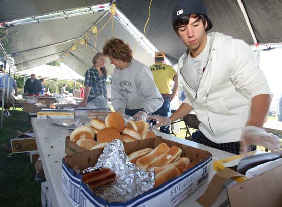 Priscilla Harrod and Zak Shultz prepare hot dogs at the Lions Club food tent.