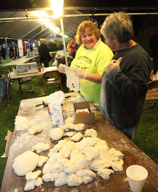 Lynn Cooke (left) and Shirley Boudreau roll out thawing dough to be turned into fried dough, a crowd-pleaser.