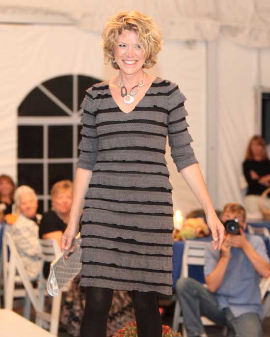 Harvard Farmers' Market organizer Rochelle Greayer wears a charcoal grey ruffled dress by Frank Lyman Designs along with bold jewelry by Pastore.