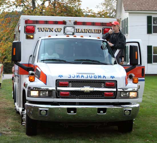 John Lee uses the ambulance PA system to gather runners before the race.