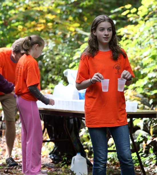 Sophia Collins waits with cups in hand for runners to pass through the first water stop.