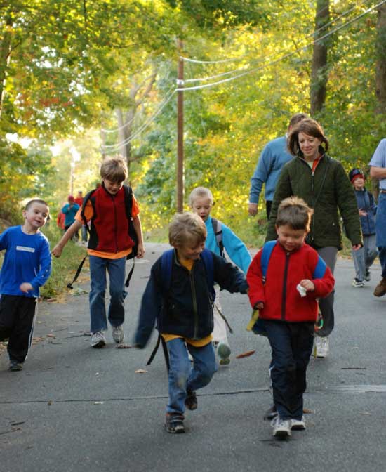 Nicholas Thornton and Ethan Taylor (center) lead a group of students and parents as they walk down Oak Hill Road on their way from Carlson Orchards to the elementary school on International Walk to School Day, October 8. (Photo by Sue Fitterman)