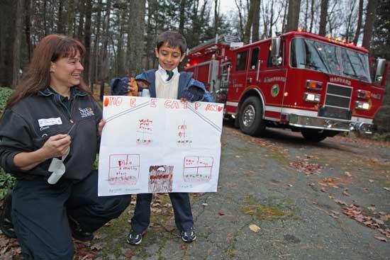 Firefighter Oona Aldridge takes a look at Arjun Kharana’s fire safety poster before he hops on the truck.
