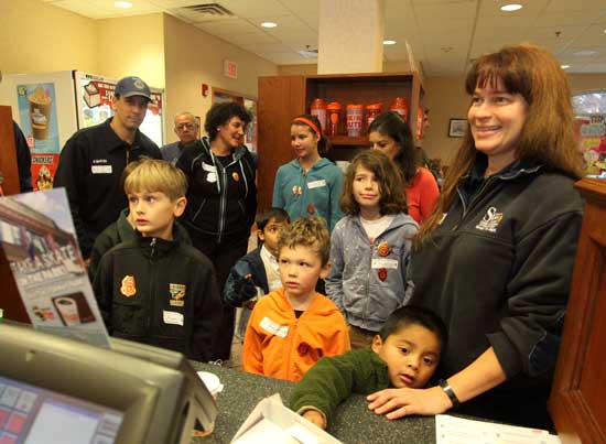 A group of fire safety award winners place their breakfast orders at Dunkin’ Donuts as guests of the Harvard Fire Department.  Each year the department selects a winner from each grade, pre-K through 5, who make posters or in another way convey what they have learned during fire safety week.